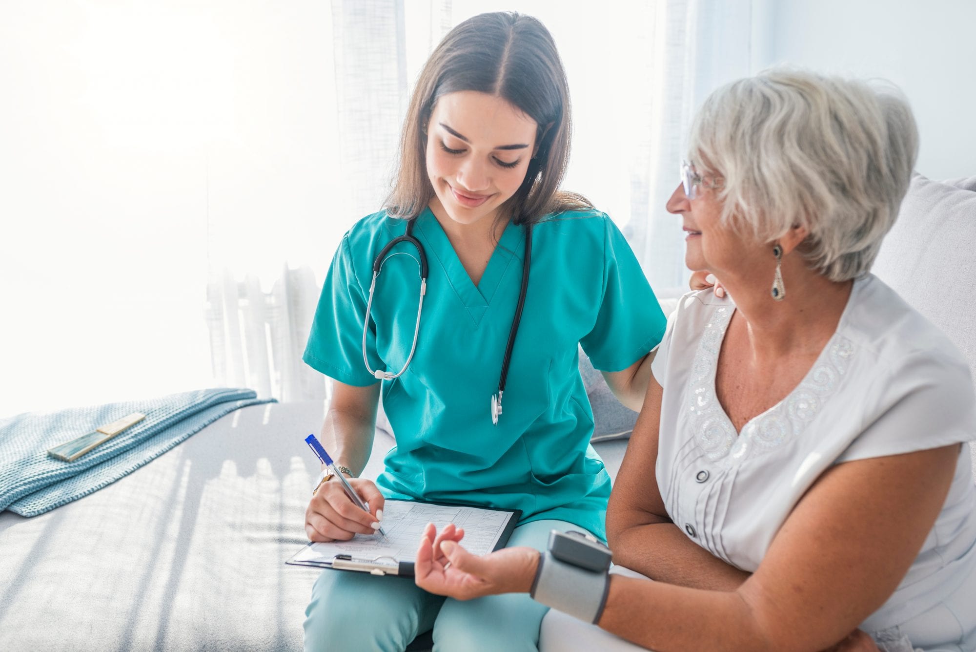 nurse measuring older woman's blood pressure