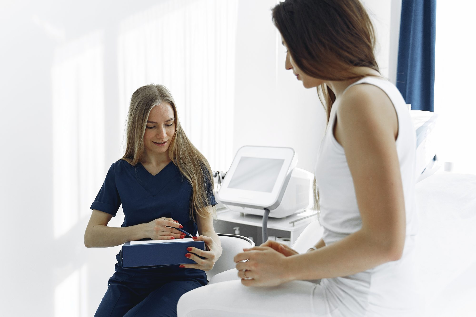 female nurse speaking to femal patient in room