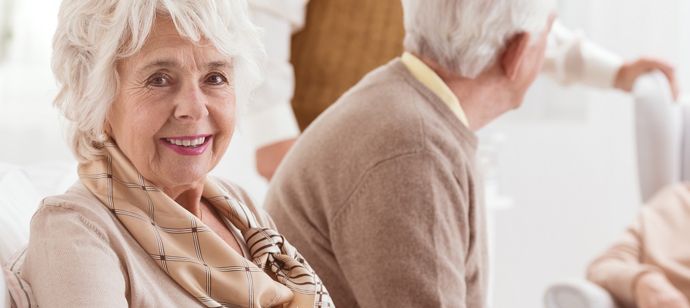 Smiling senior woman and her friends chatting in a retirement home